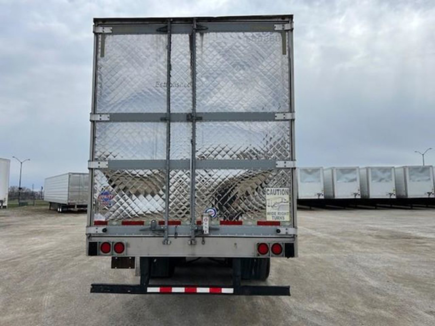 Rear view of a 2019 Utility refrigerated trailer with diamond plate doors, cargo area, rear bumper, and red/white reflective tape.