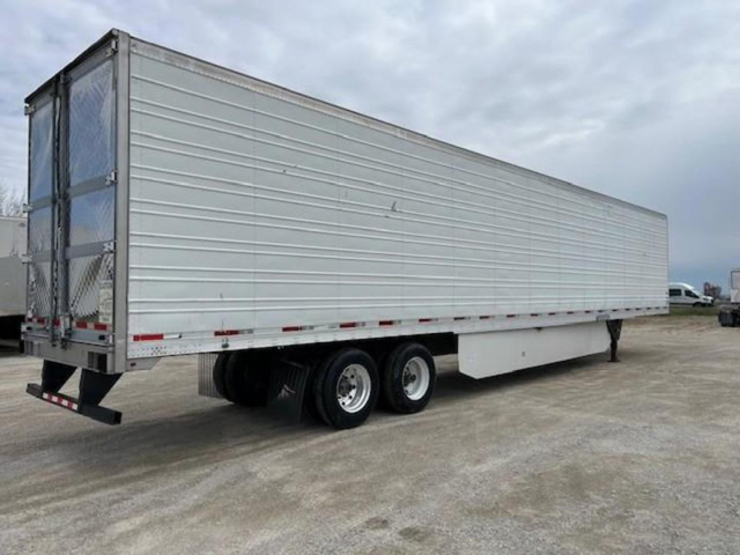 Utility reefer trailer side view showing aluminum walls and tandem axle configuration.