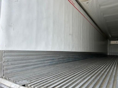 Interior of a 2019 Utility Reefer trailer cargo area with ribbed metal floor and insulated walls; side wall shows a red seam line.
