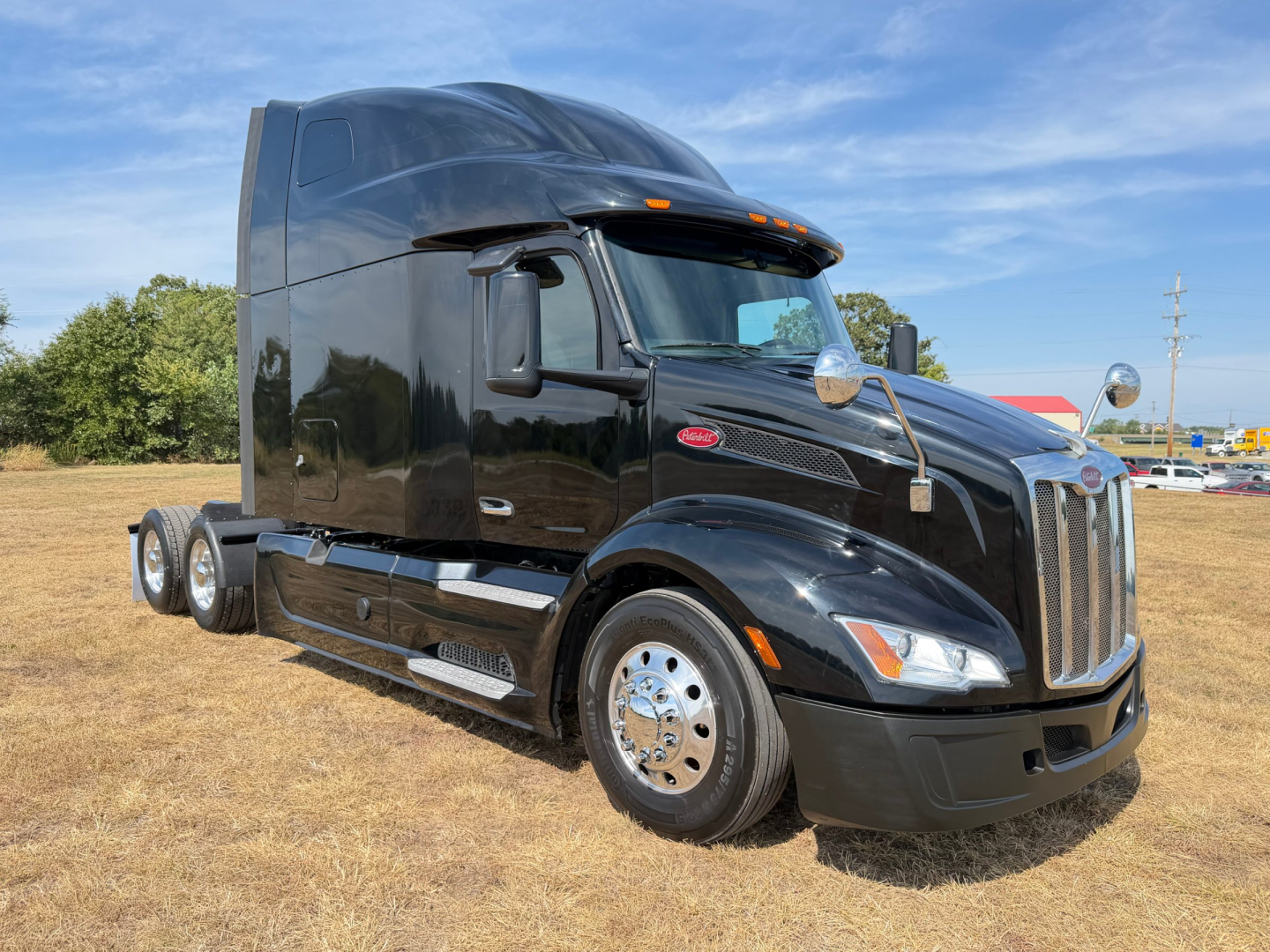 Peterbilt 579 truck in service condition, black exterior, sleeper cab, side view showing chrome wheels and aerodynamic design.