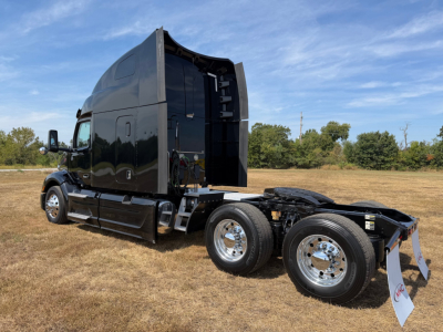 Peterbilt 579 truck in profile view showing cab, sleeper, and dual rear axles with chrome wheels and black paint.