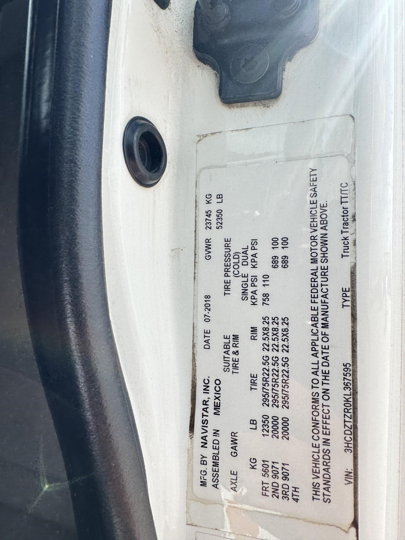 Vehicle VIN plate on International LT showing weight ratings, tire/GA, and vehicle basic data with label text visible.