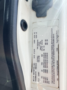 Vehicle VIN plate on International LT showing weight ratings, tire/GA, and vehicle basic data with label text visible.