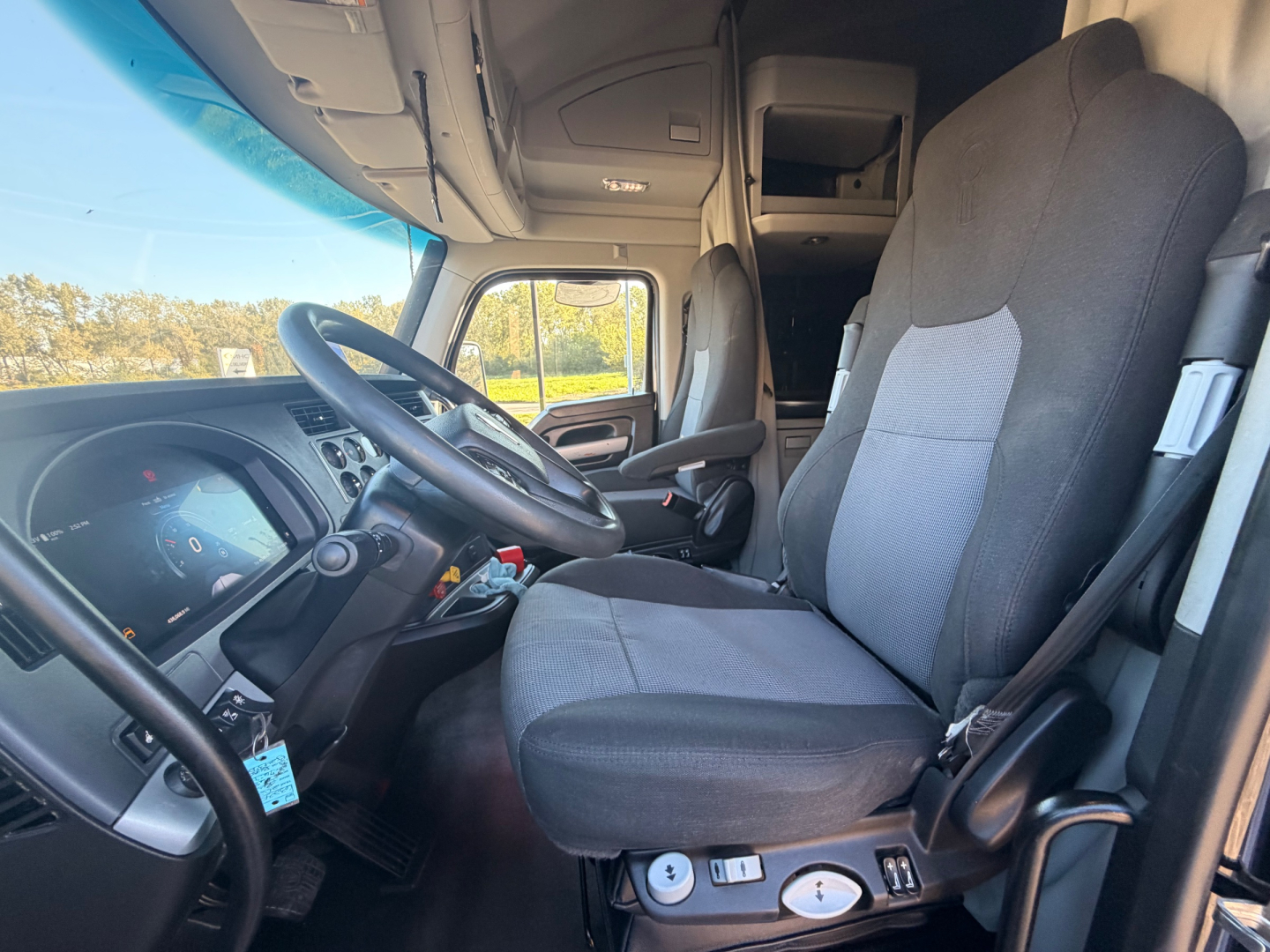 Kenworth T680 truck interior with driver seat and steering wheel visible, dashboard, and cab controls