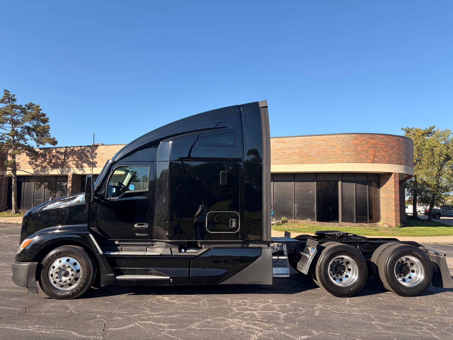 Kenworth T680 tractor in profile view showing sleeper cab, black exterior, chrome wheels, and dual rear axles.