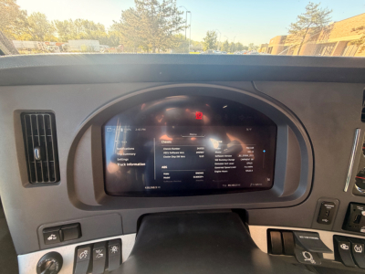 Kenworth T680 dash with digital display showing vehicle information and controls on the center panel.