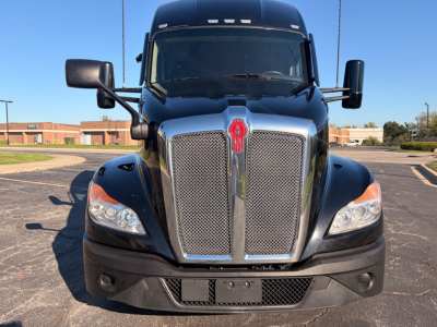 Front view of a black 2023 Kenworth T680 conventional sleeper truck showing dual chrome grid grille, emblem in center, large headlights, and side mirrors.