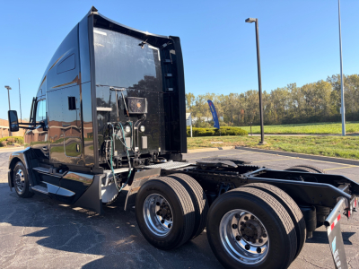 Kenworth T680 tractor rear view showing raised sleeper cab, dual rear axles, fifth wheel area, and chrome wheels.