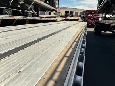 Utility 4000Ae combo drop deck trailer bed showing aluminum deck with side rails and stake pockets, perspective from front corner.