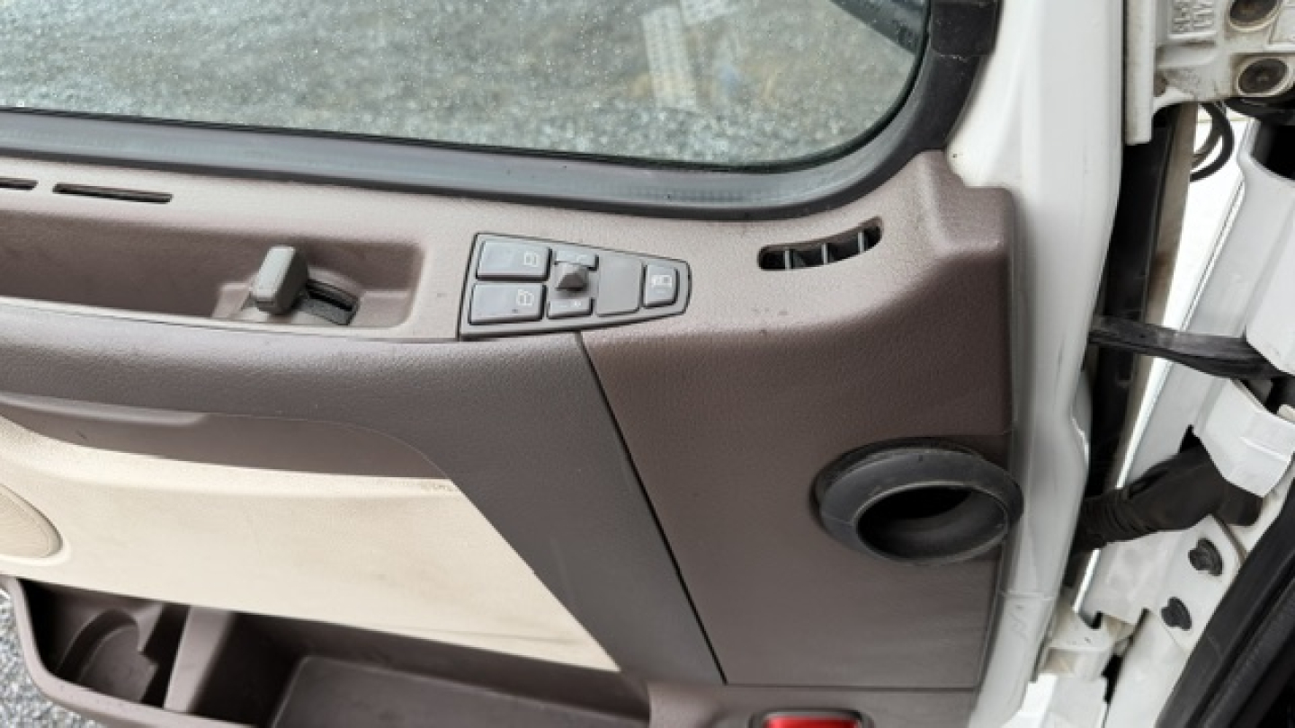 Interior of Volvo VNL truck cabin with door panel and control switches visible.