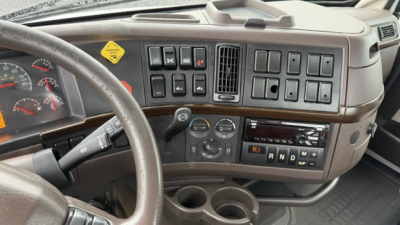 Volvo VNL64T300 cab interior showing dashboard switches, steering wheel, and instrument cluster with climate controls and gear selector.