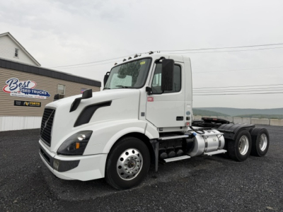 Volvo VNL64T300 semi tractor truck in white side view showing cab and front axle, fuel tanks, and dual rear axles.