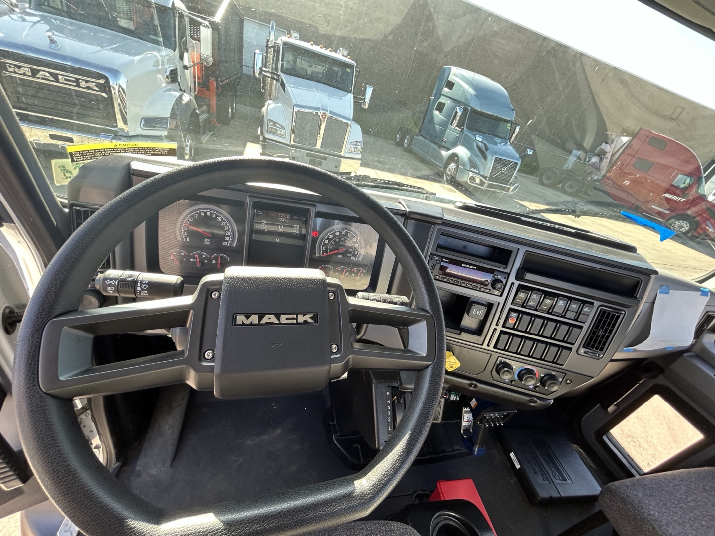 Mack MD7 truck cab interior showing steering wheel, instrument cluster, and dashboard controls.