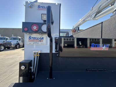 Truck bed view of a 2025 Mack MD7 service truck with Stellar crane equipment, Stella branding, and hydraulic hoses visible near the rear.