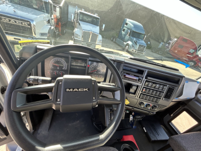 Mack MD7 truck cab interior showing steering wheel, instrument cluster, and dashboard controls.