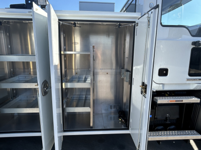 MD7 service body with open rear compartments showing metal shelving and storage cabinets.