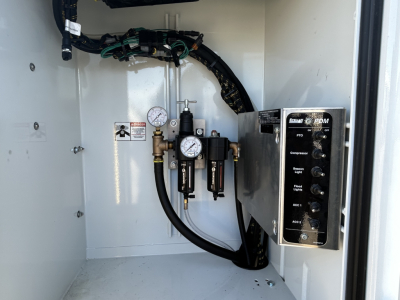 Mack MD7 service truck interior with hydraulic manifold and gauges showing label text, control panel, hoses, and pressure gauges.