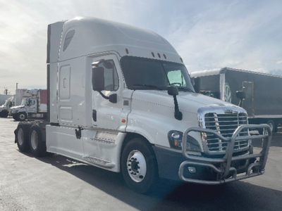 Truck cab side view of a white 2018 Freightliner Cascadia125 Evolution tractor with protective front bumper and grille, sleeper cab, three-axle tractor.