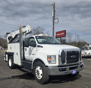 Ford F-750 service/utility truck showing boom lift and utility body with white cab and black grille
