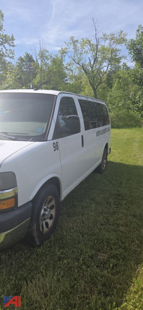 2013 Chevrolet Express van side view showing passenger van, number 98 on door, in-service white exterior.