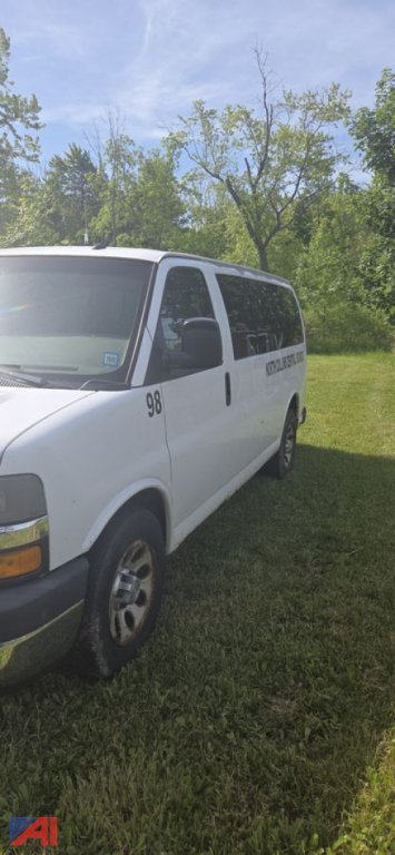 2013 Chevrolet Express van side view showing passenger van, number 98 on door, in-service white exterior.