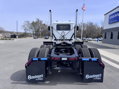 Rear view of a new 2027 Mack PI64T daycab tractor showing dual rear axles and mud flaps labeled Bruechner's Equipment.