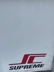 SCV Supreme logo visible on a light surface; no vehicle information readable in this image.