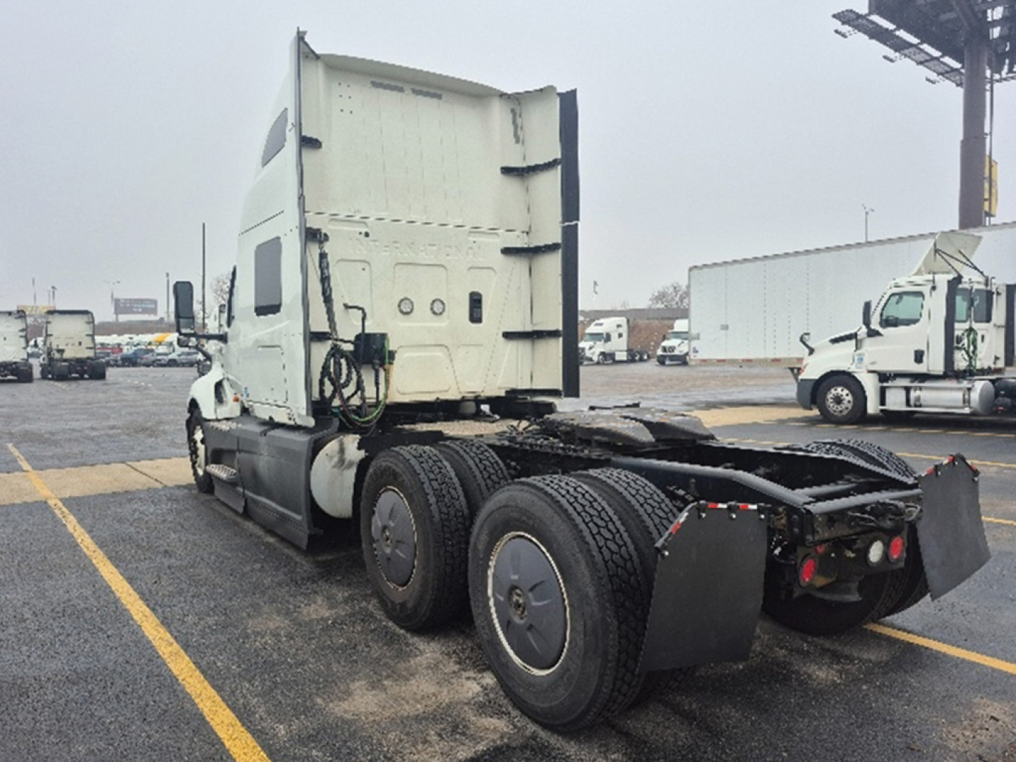 Truck cab and chassis of a used 2023 International LT625 tractor viewed from rear-left, showing dual rear axles and fifth-wheel area.