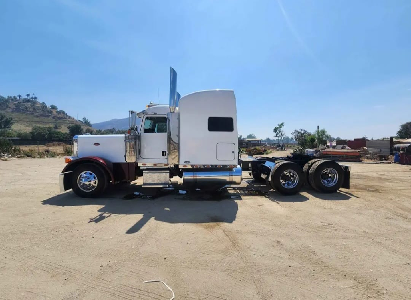 Peterbilt 379 tractor side profile showing long nose, white cab, chrome exhaust stacks, and dual rear axles.