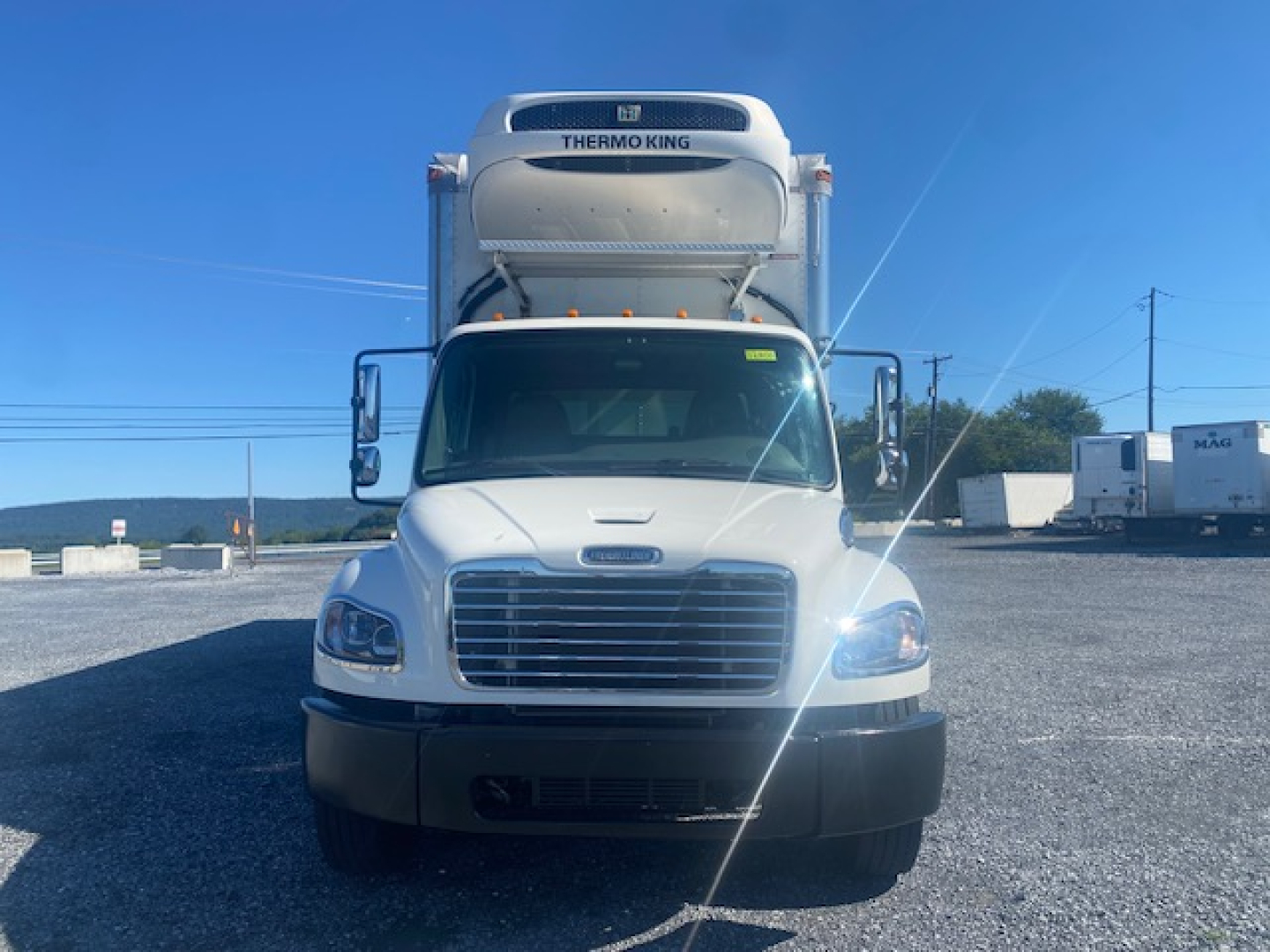 Front view of 2019 Freightliner M2 106 refrigerated truck with Thermo King unit mounted on top, headlights and grille visible.