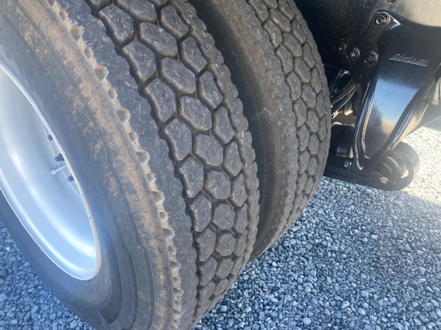 Freightliner M2 106 rear dual tires with visible tread pattern and suspension components.