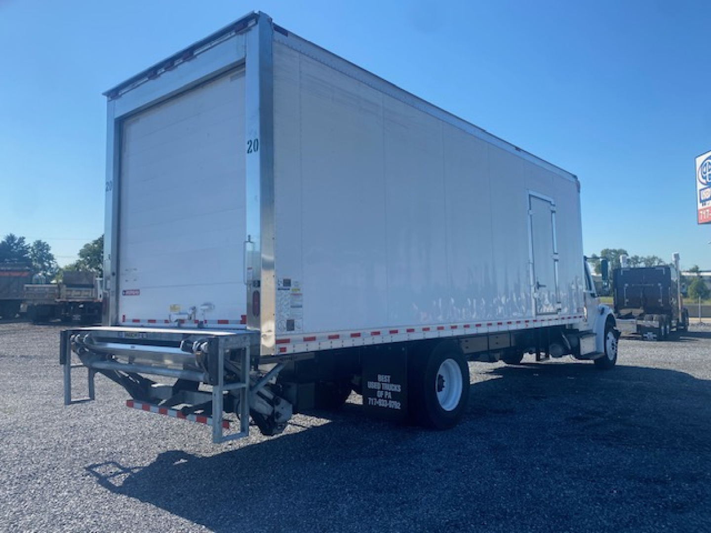 Freightliner M2 106 refrigerated box truck rear-left view showing cargo box and support bumper.