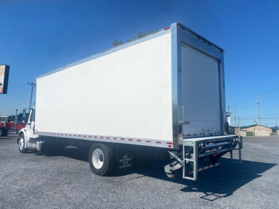 Freightliner M2 106 refrigerated truck side and rear showing cargo box, rear lift gate, and dual rear wheels.