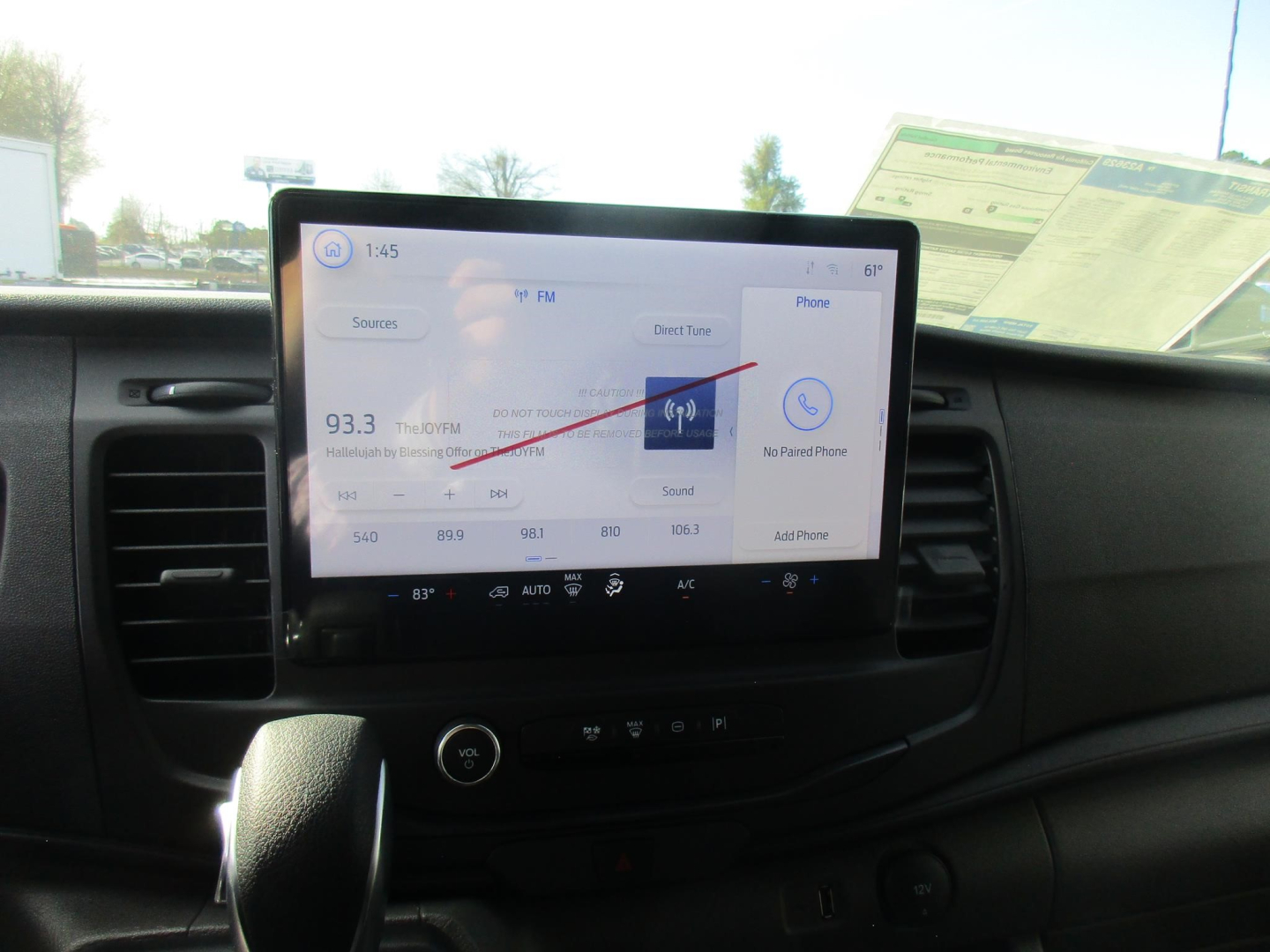 Ford Transit cargo van dashboard with large touchscreen displaying radio 93.3 FM and phone screen in center console.