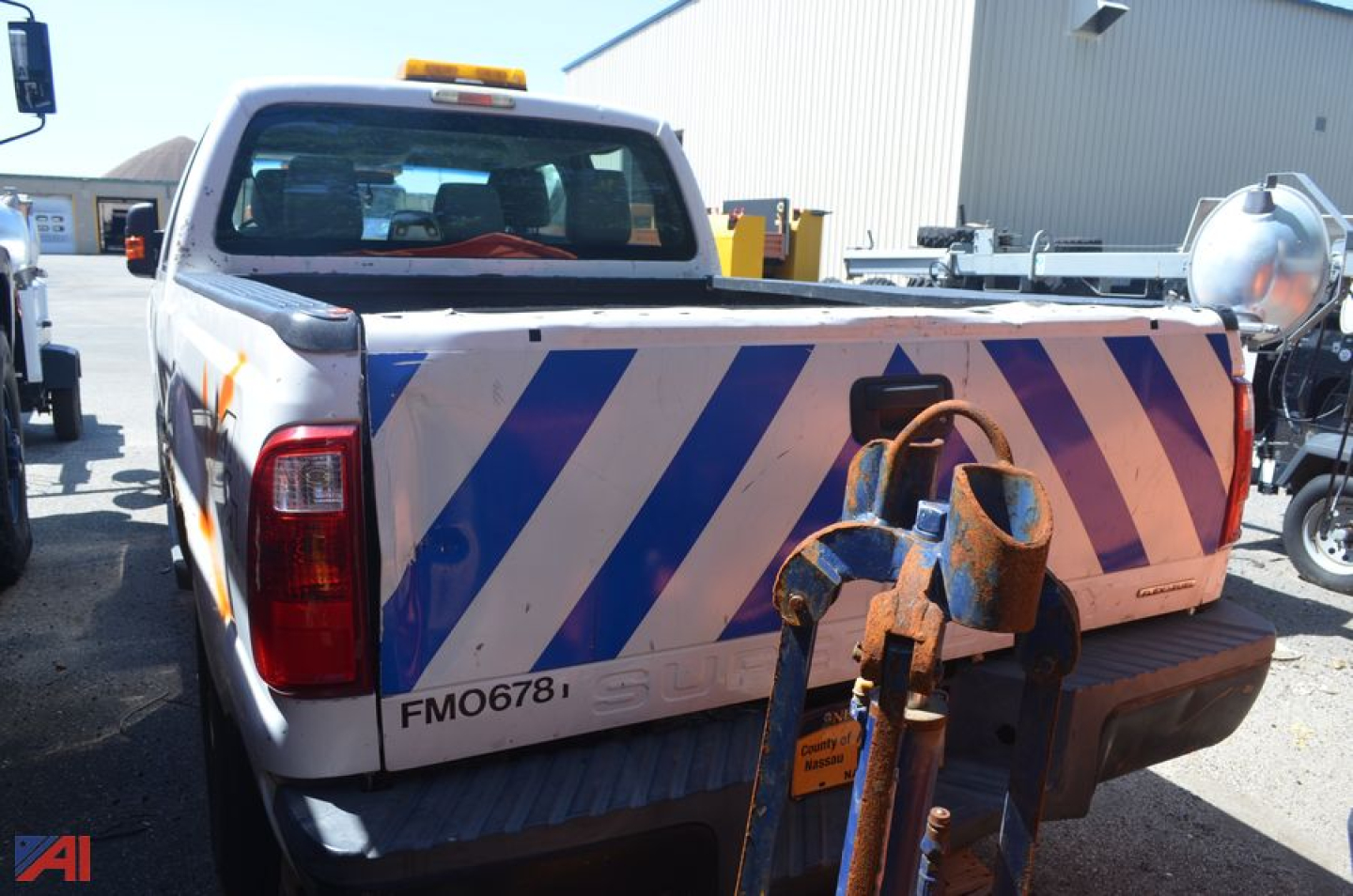 Ford F-250 Super Duty pickup truck rear view with striped reflective markings and tow equipment.