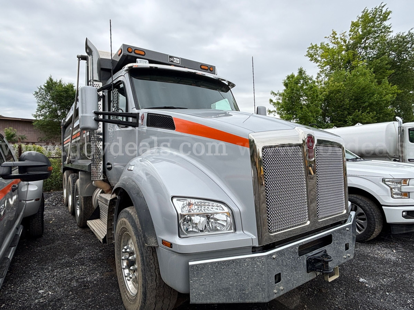 2021 Kenworth T880 dump truck in-service view showing front grille, chrome bumper, and Kenworth emblem.