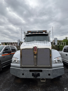 Kenworth T880 dump truck front view showing large chrome grille with Kenworth emblem and bumper.