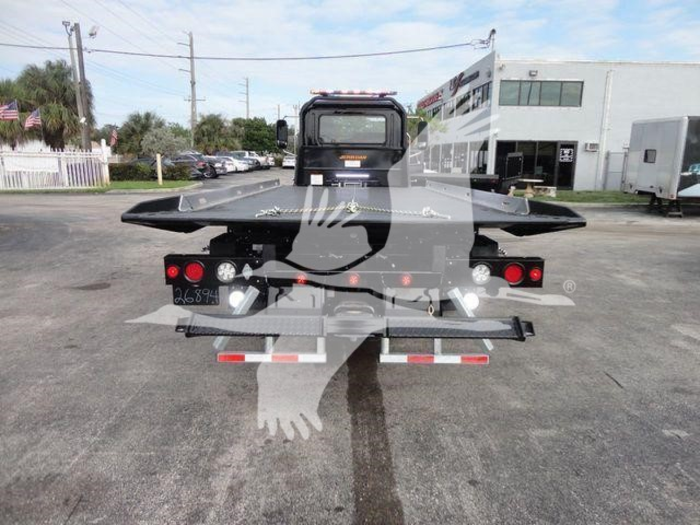 Back view of a new 2027 Mack MD6 rollback truck showing rear platform and taillights.