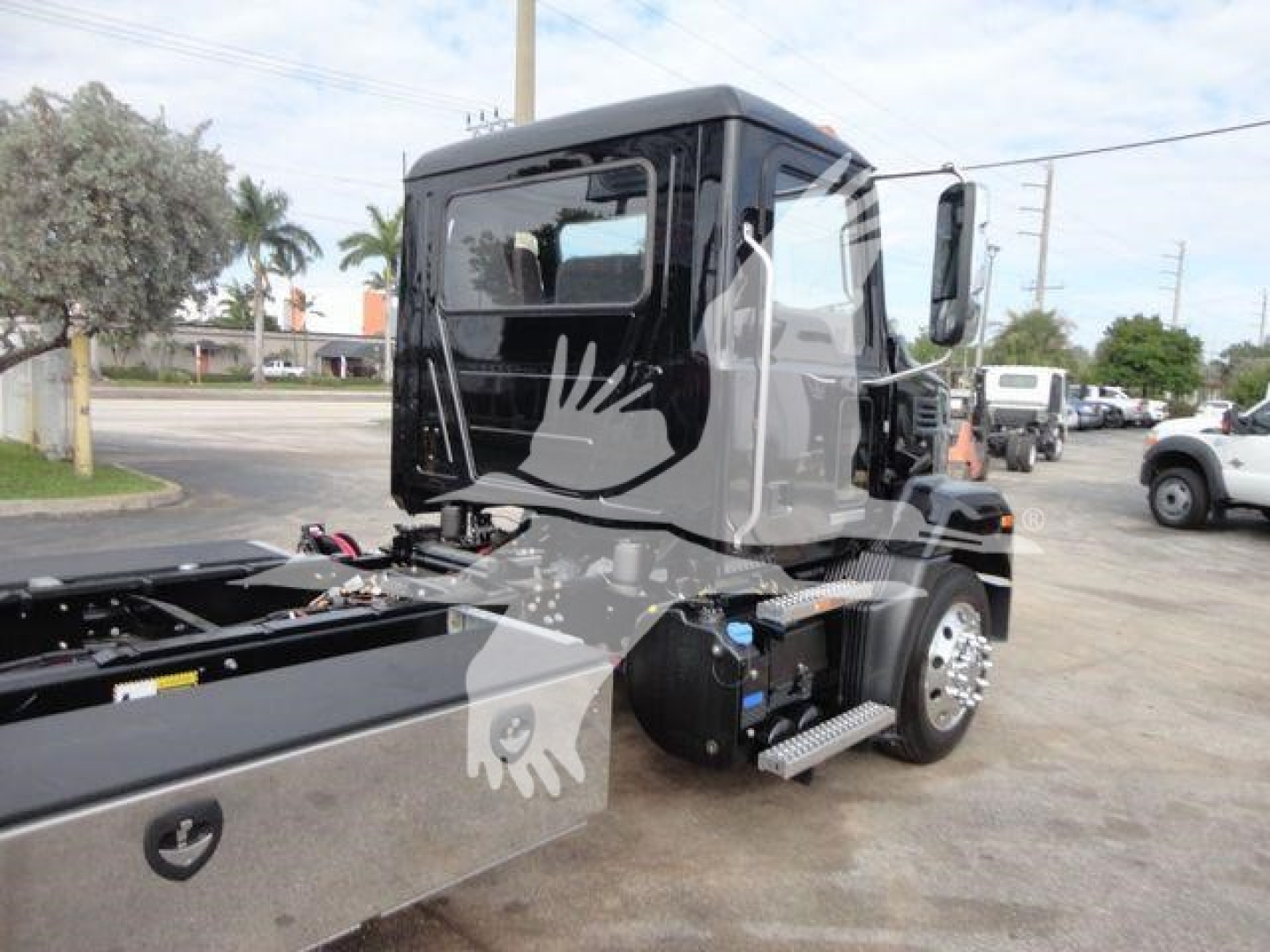 Truck cab of a 2027 Mack MD6 rollback unit showing side cab and chassis with steps and fuel tank.