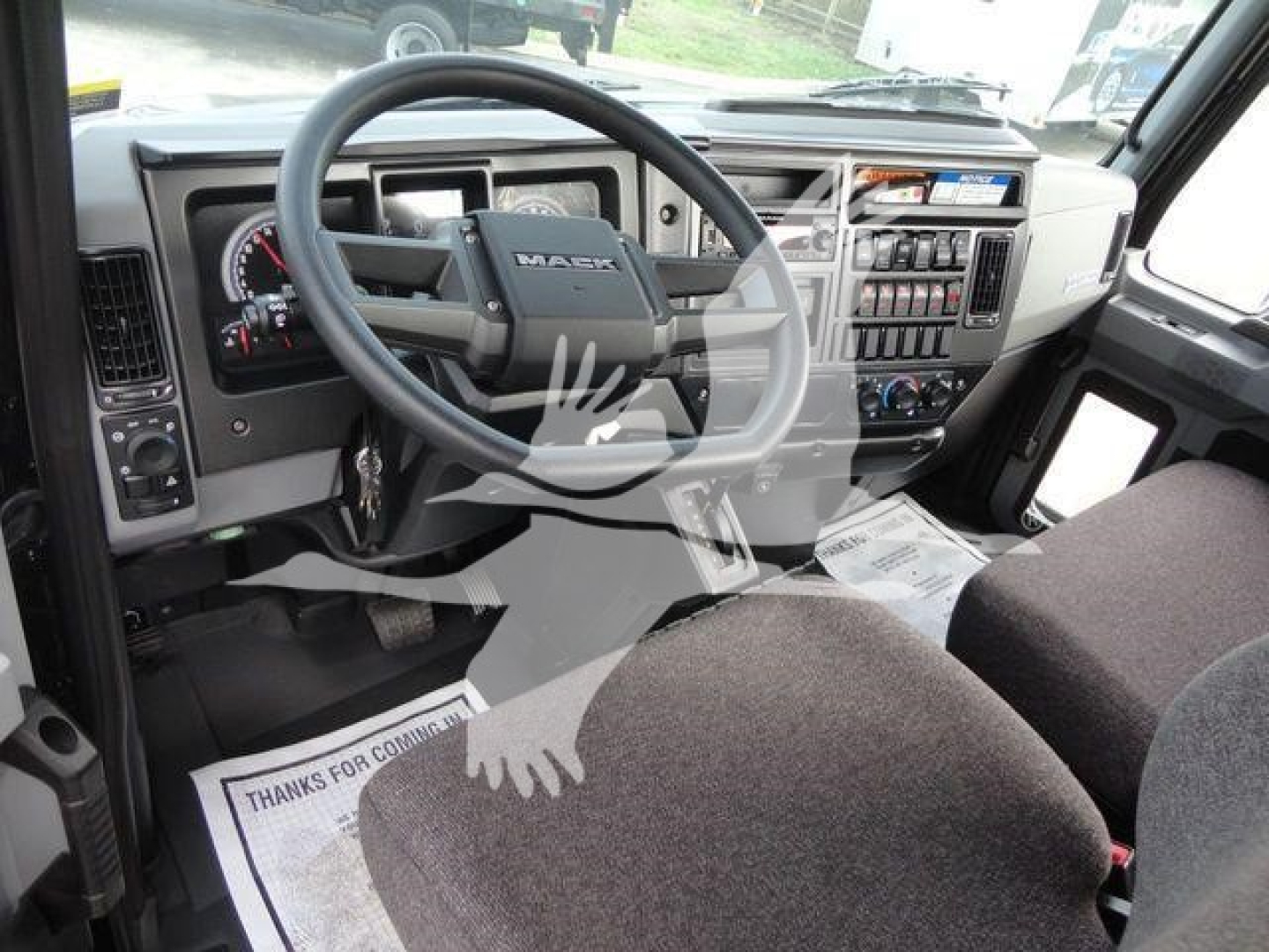 Dashboard and steering wheel of a new 2027 Mack MD6 truck showing instrument cluster and controls
