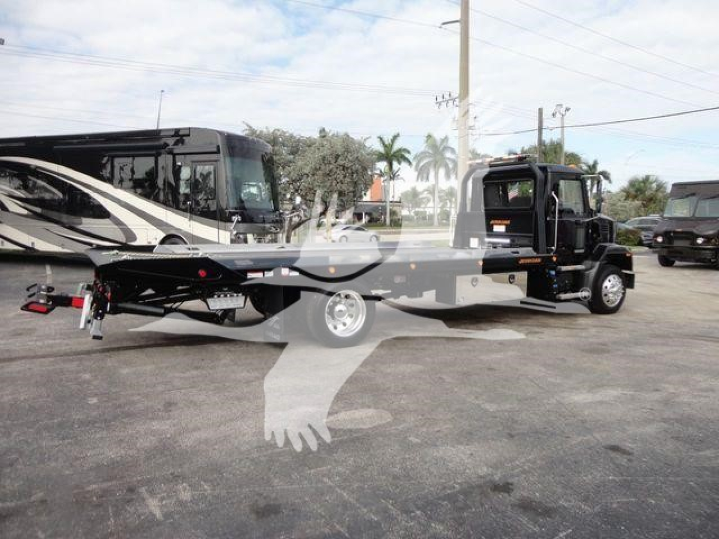 Truck showing rollback tow truck with flatbed and wrecker equipment; visible text includes J07254 stock number label and Mack MD6 chassis in background.