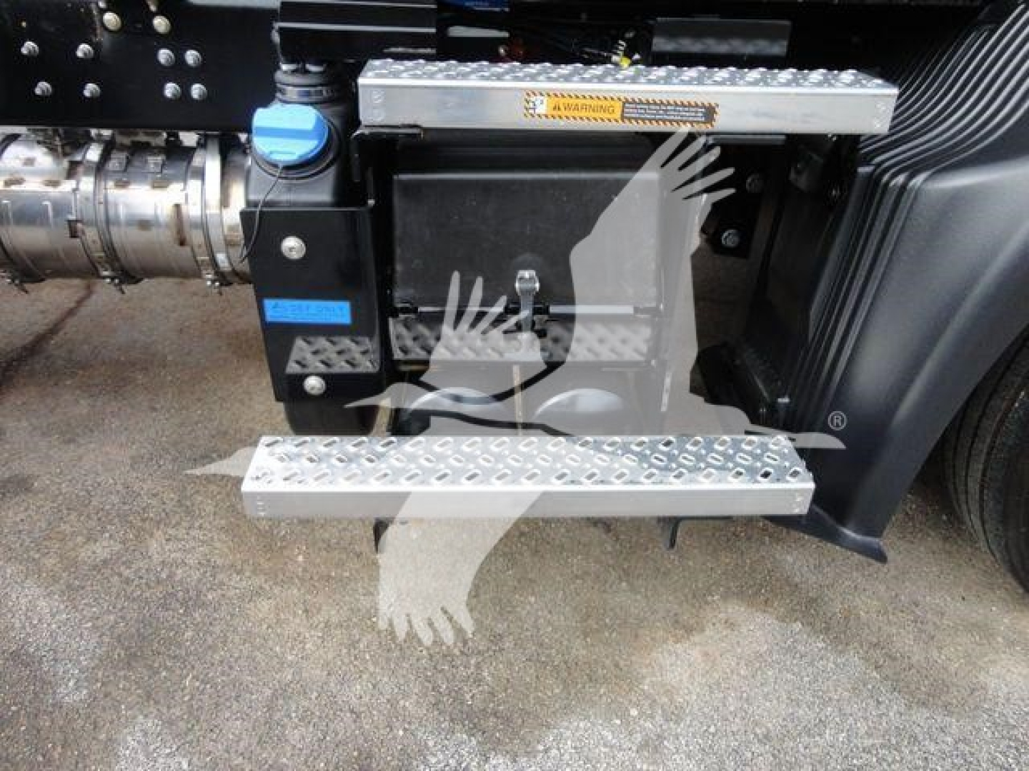Truck side view showing diamond plate steps and blue cap fluid reservoir with Mack MD6 tag area.