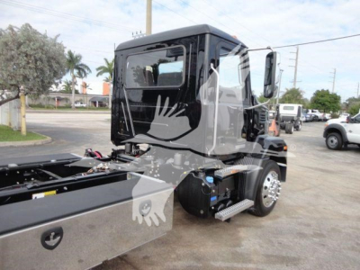 Truck cab of a 2027 Mack MD6 rollback unit showing side cab and chassis with steps and fuel tank.