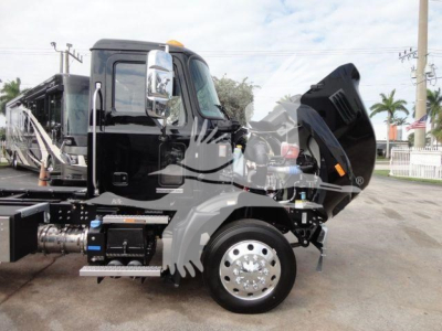 Truck hood open showing engine bay and hydraulic components on a 2027 Mack MD6 rollback truck, chrome wheel, black cab, raised hood, side step, and front fender.