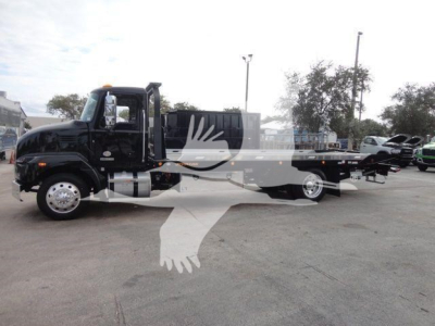 Truck bed tow/rollback body on a black 2027 Mack MD6 truck in a dealership lot.
