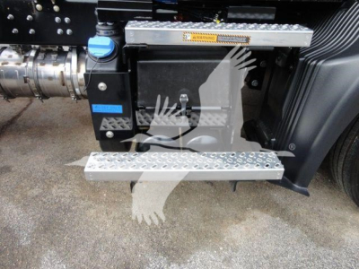 Truck side view showing diamond plate steps and blue cap fluid reservoir with Mack MD6 tag area.
