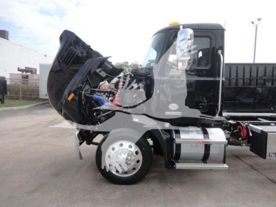 Truck engine bay with hood up showing Mack MD6 cab and front wheel, side view.