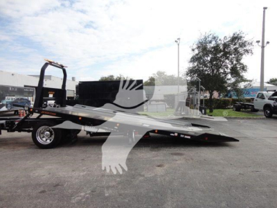 Mack MD6 rollback truck with flatbed and hydraulic ramps, side view showing deck and hitch.
