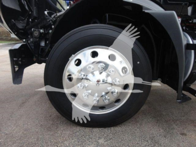 Mack MD6 front wheel showing polished steel hub with multiple lug nuts and black tire; partial cab and fender visible.