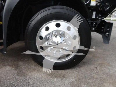 Wheel assembly of a Mack MD6 truck showing a polished chrome front hub and black tire.